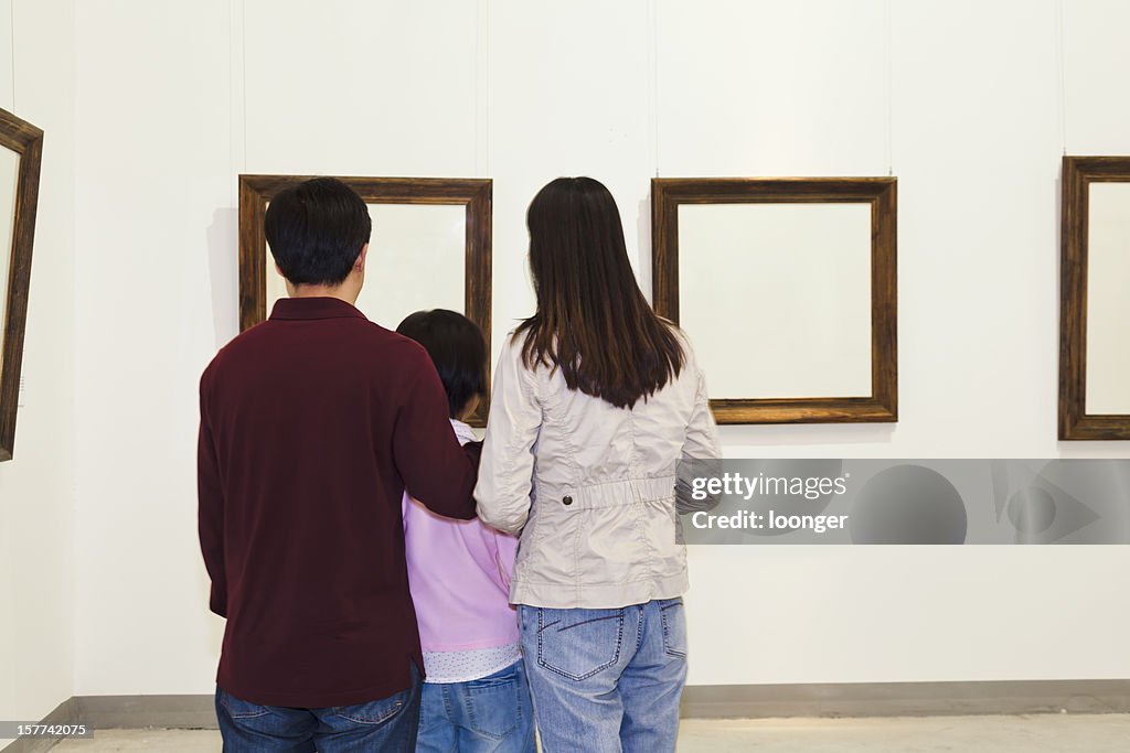 Family looking at painting in an art gallery