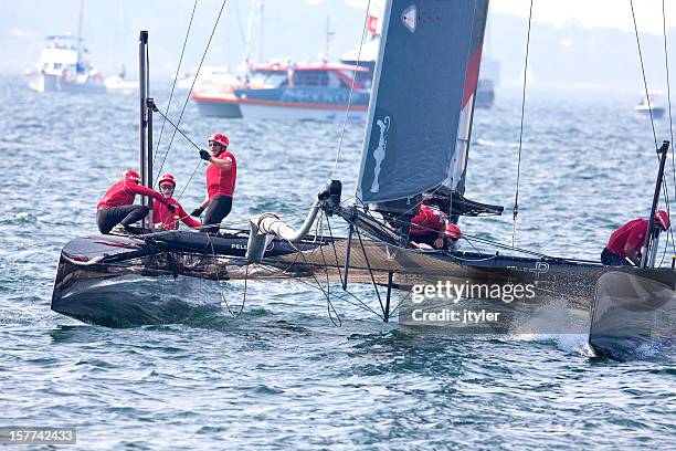 yacht racing crew hard at work - racing catamaran stock pictures, royalty-free photos & images