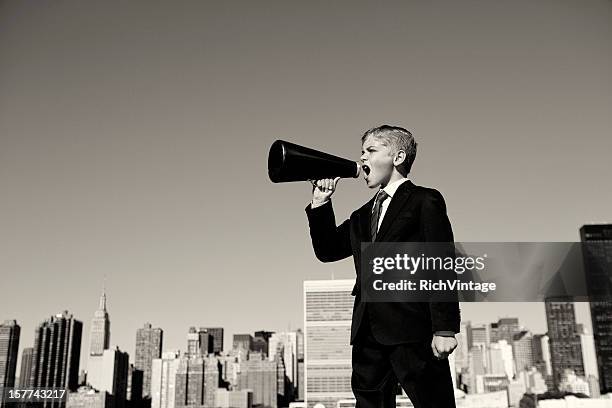 boy businessman yelling through megaphone in new york city - toned image stock pictures, royalty-free photos & images