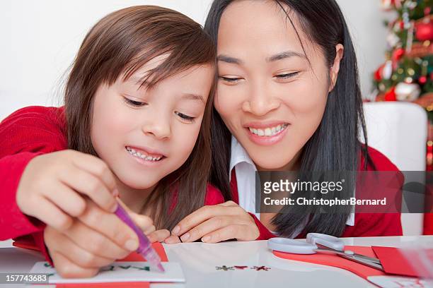 asian mother and daughter making christmas cards - christmas colouring stock pictures, royalty-free photos & images