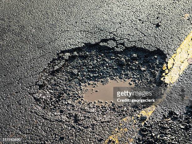 dangerous pot hole on the road - bad condition stock pictures, royalty-free photos & images