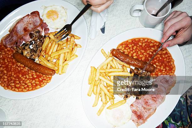 two plates of full english breakfast - english breakfast stock-fotos und bilder