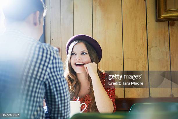 young woman and man chatting in cafe - sprechen zusammen cafe stock-fotos und bilder