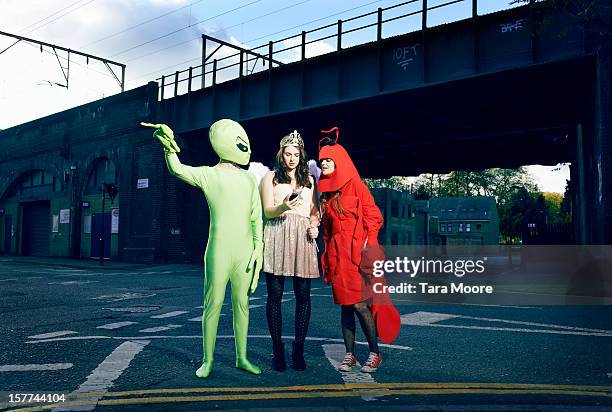 friends in fancy dress checking mobile for map - verkleden stockfoto's en -beelden