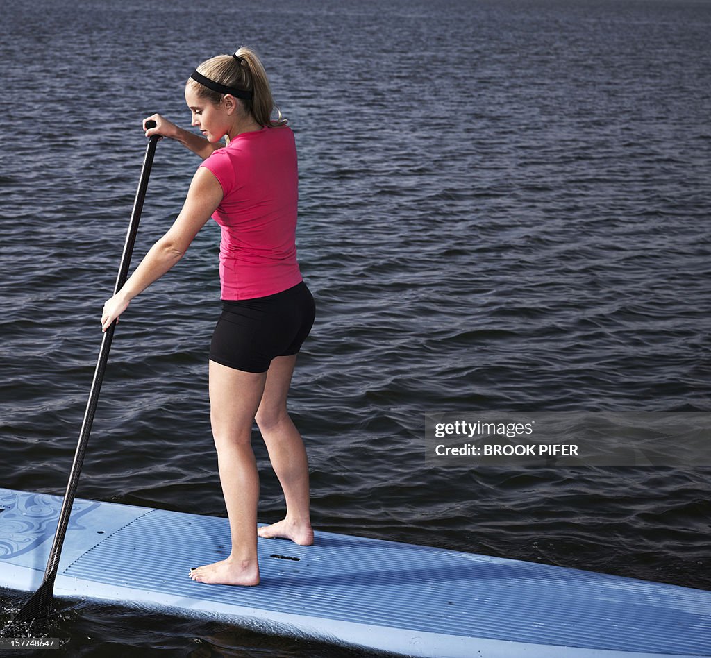 Young woman athlete on stand up paddle board