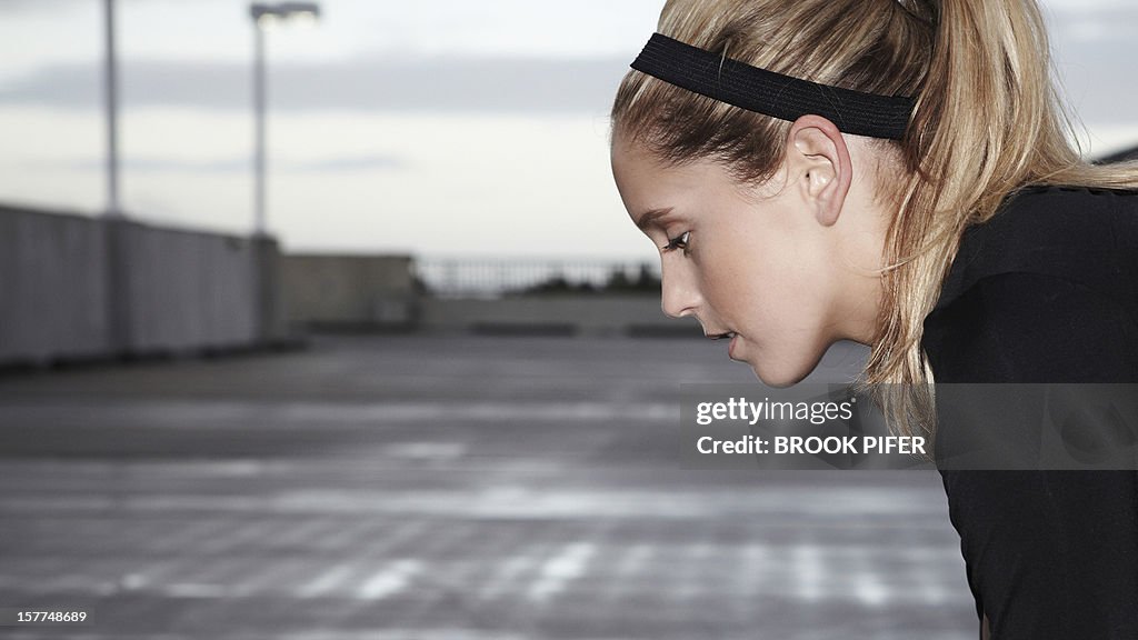 Young woman athlete looking down
