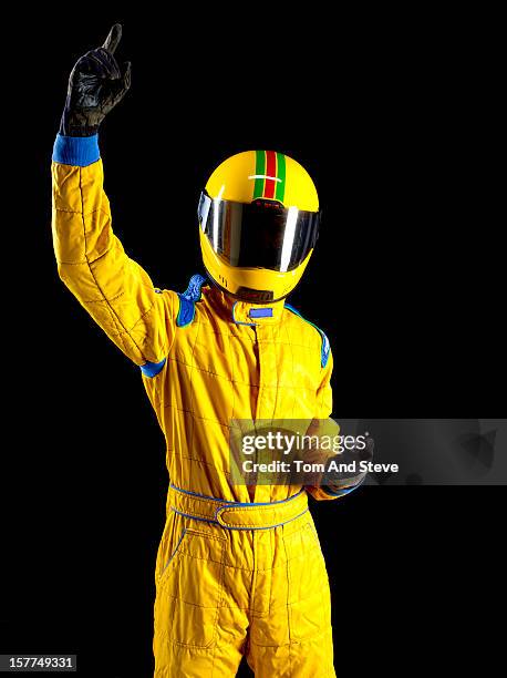racing driver with finger in the air for winning! - racing suit stock pictures, royalty-free photos & images