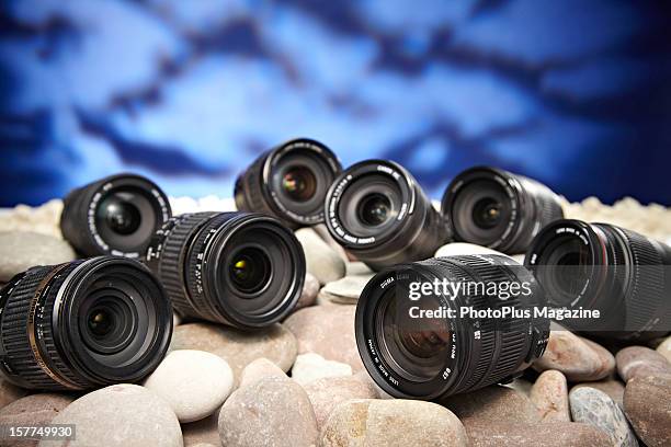 Selection of superzoom SLR lenses on a bed of rocks, taken on April 20, 2012.