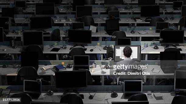 an office worker sits working in an empty office - assenza foto e immagini stock
