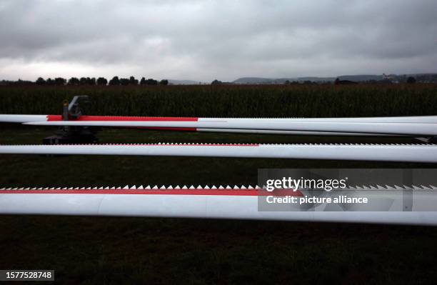 August 2023, Bavaria, Fuchstal: Rotor blades of a wind turbine lie ready for assembly under a cloudy sky in the early morning. Photo: Karl-Josef...