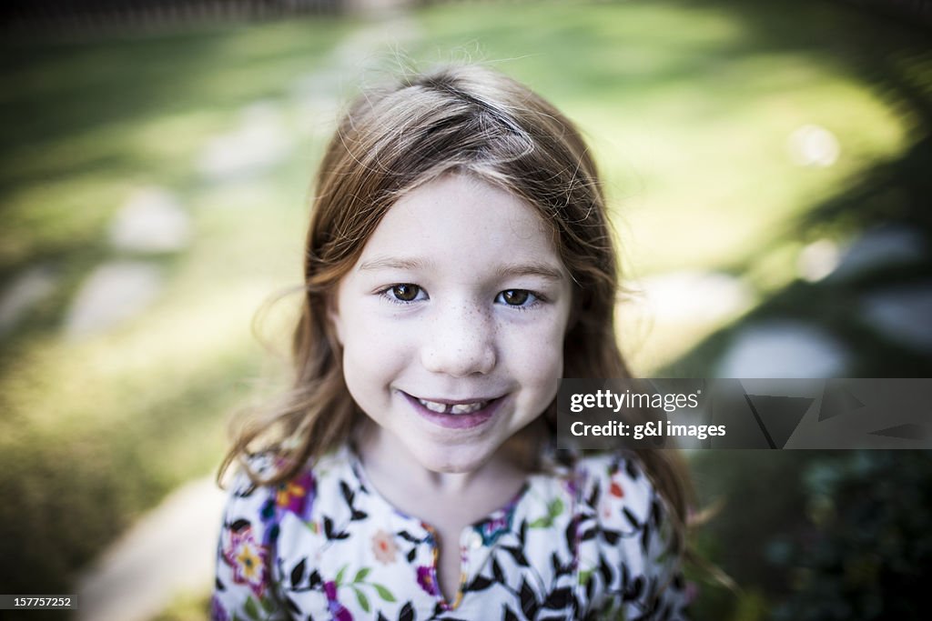 Portrait of girl (6yrs) smiling, outdoors