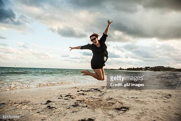 woman jumping on mexico beach - hochspringen stock-grafiken, -clipart, -cartoons und -symbole