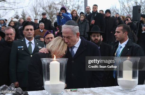 Israeli Prime Minister Benjamin Netanyahu kisses his wife Sara after the two laid a wreath and lit candles at Track 17, the place where the Nazis...