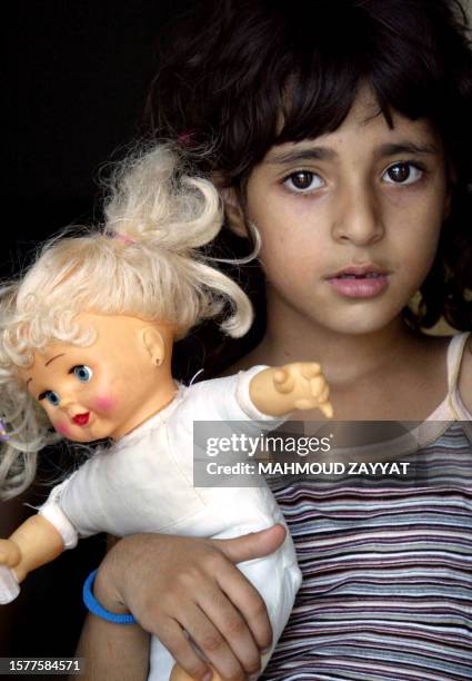 Lebanese girl Zahra Awali displaced from the southern Lebanese village of Tulin carries her doll which she refused to leave behind fearing she might...