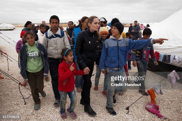 In this handout image provided by UNHCR, UNHCR Special Envoy Angelina Jolie meets with refugees at the Zaatari refugee camp on December 6, 2012...