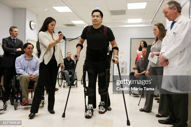 Forty three-year-old parapalegic Robert Woo walks with an exoskeleton device made by Ekso Bionics during a demonstration at the opening of the...