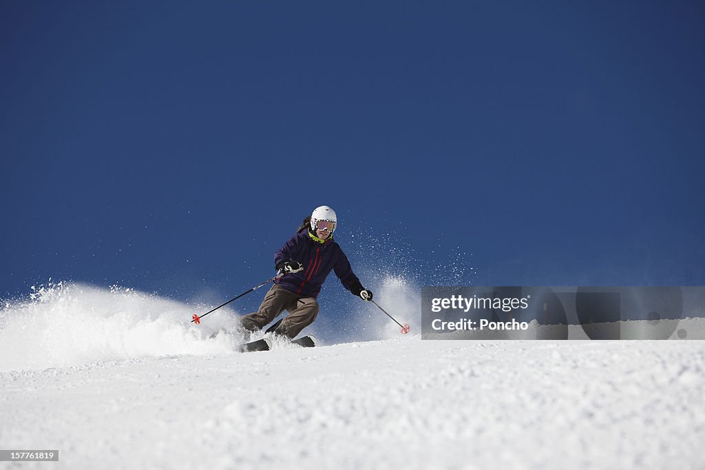Woman skiing down a piste