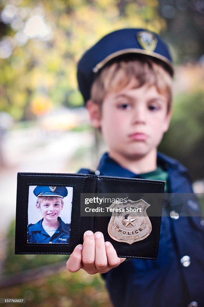 Boy in Costume Holds Police Badge