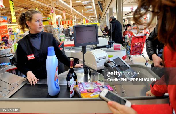 Customer pays at a register with a smartphone application on December 6, 2012 in a Auchan supermarket in Faches-Thumesnil near Lille, northern...