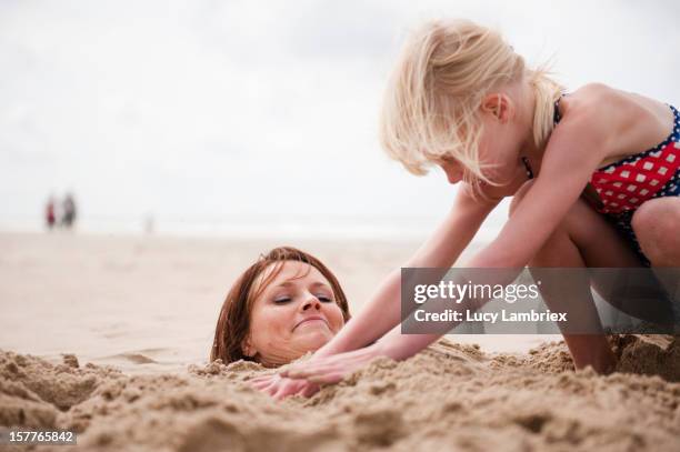 making a sand mermaid - buried in sand stockfoto's en -beelden