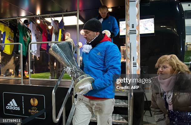 Man carries the UEFA Europa League official trophy in front of the Europa League truck parked outside the stadium in Maribor, during the NK Maribor...