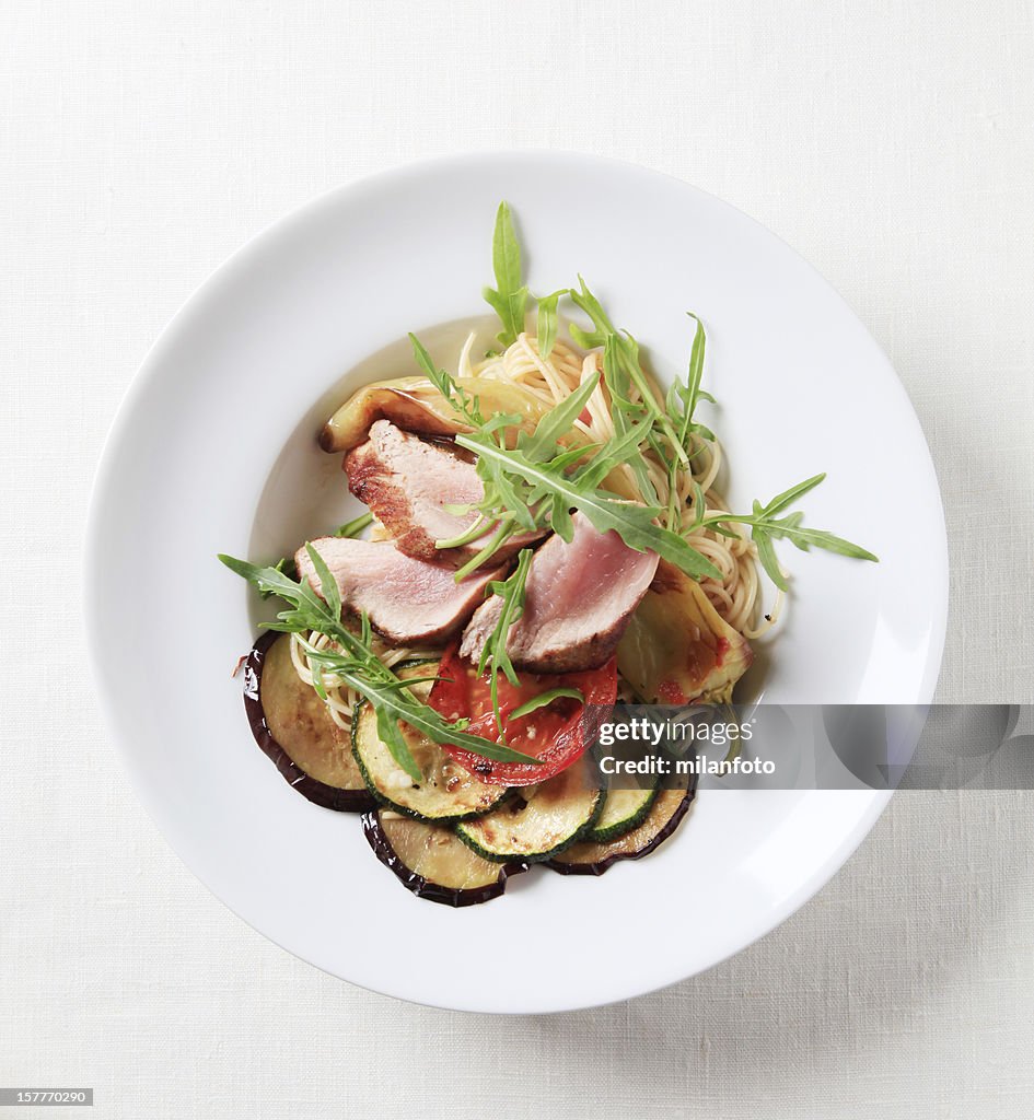 Roast pork with spaghetti and baked vegetables