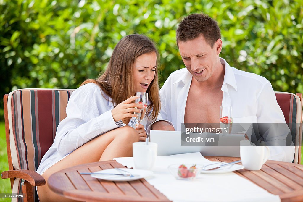 Couple with laptop having fun outdoor