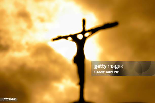 cross against a dark yet bright sky symbolizing forgiveness - cross stockfoto's en -beelden