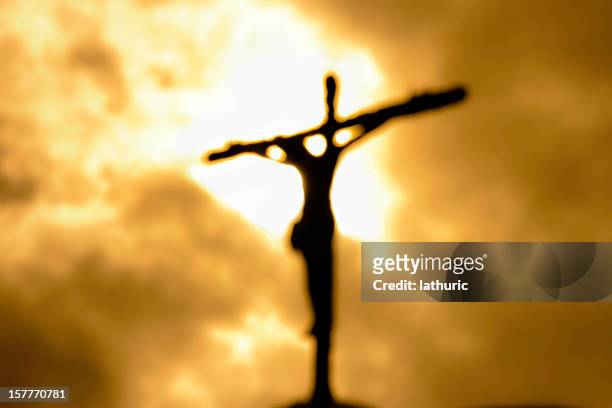 cross against a dark yet bright sky symbolizing forgiveness - jesus christ stock pictures, royalty-free photos & images