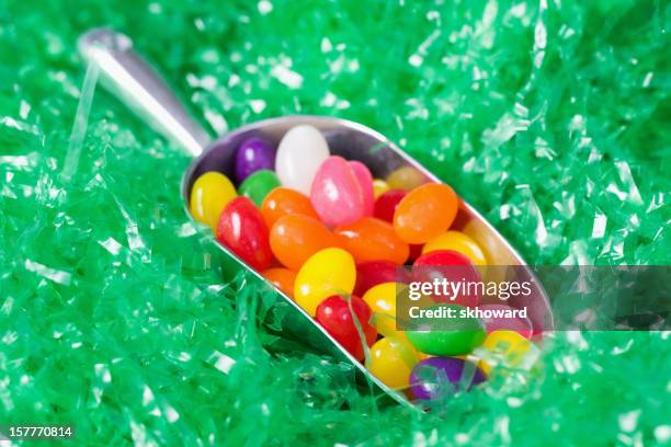 scoop of jellybeans on artificial grass - jellybean stock pictures, royalty-free photos & images