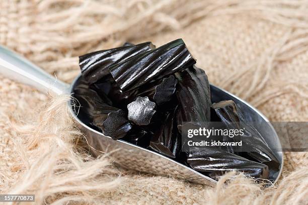 scoop of black liquorice candy on burlap - licorice stock pictures, royalty-free photos & images