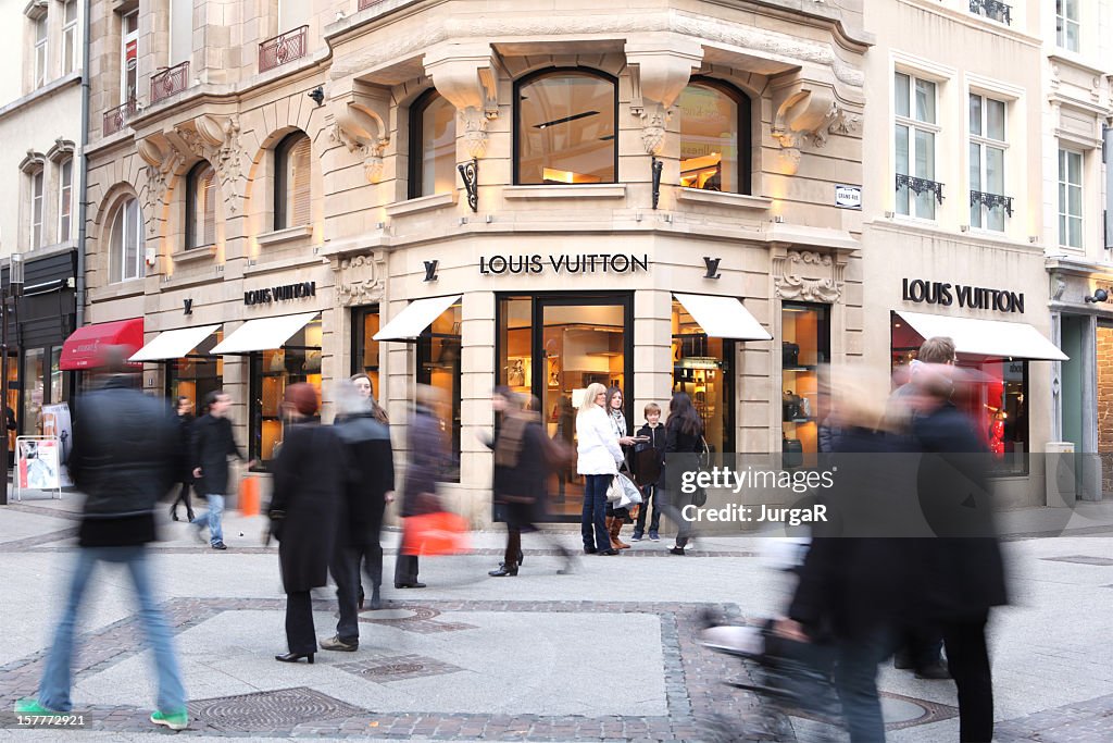 People Passing by a Louis Vuitton Store