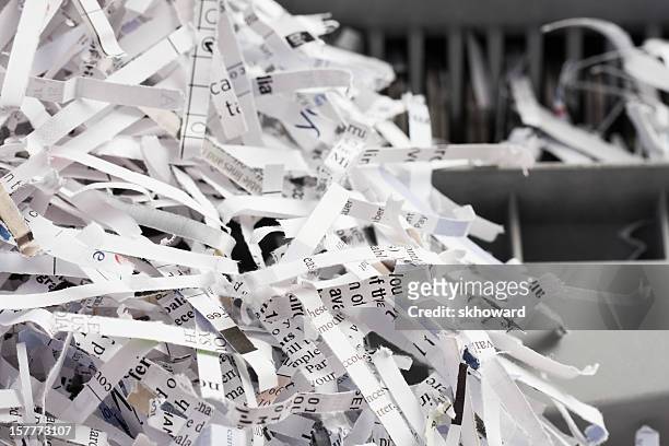 pile of shredded paper with shredder in background - shredded stockfoto's en -beelden
