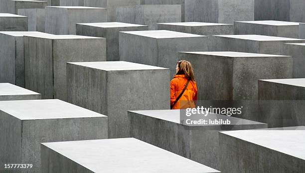 junge frau, die das holocaust-denkmal in berlin, deutschland - antisemitismus stock-fotos und bilder