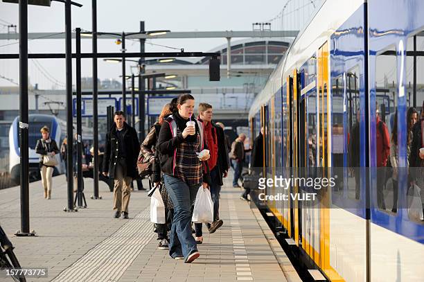 commuters boarding a train at utrecht centraal railway station - utrecht stockfoto's en -beelden
