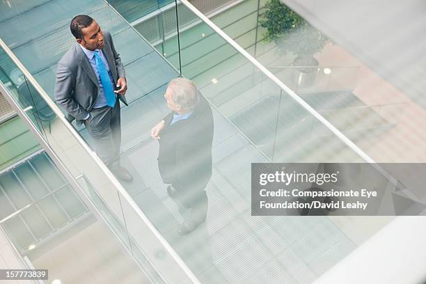 businessmen having meeting on atrium balcony - elevated walkway stock pictures, royalty-free photos & images