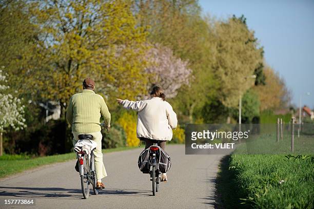 cycling couple on a country road in the netherlands - gelderland stock pictures, royalty-free photos & images