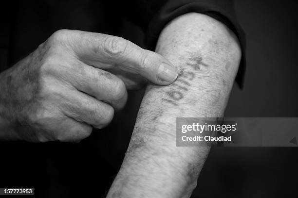 uomo anziano mostrando il suo numero è arrivato in ausschwitz - auschwitz foto e immagini stock