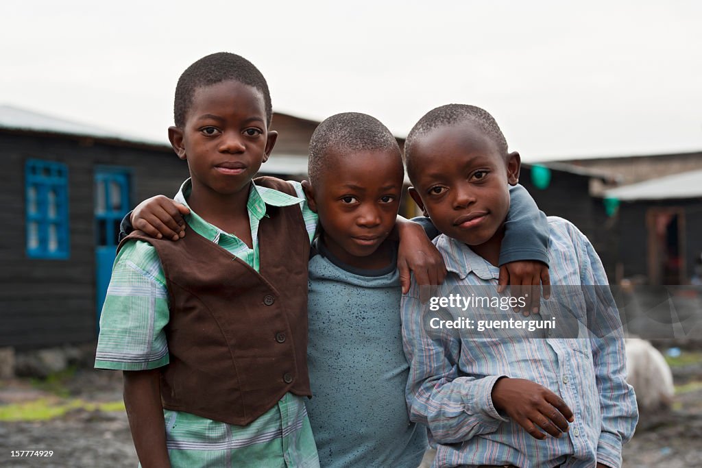 Three african boys in the destroyed town of Goma, Congo