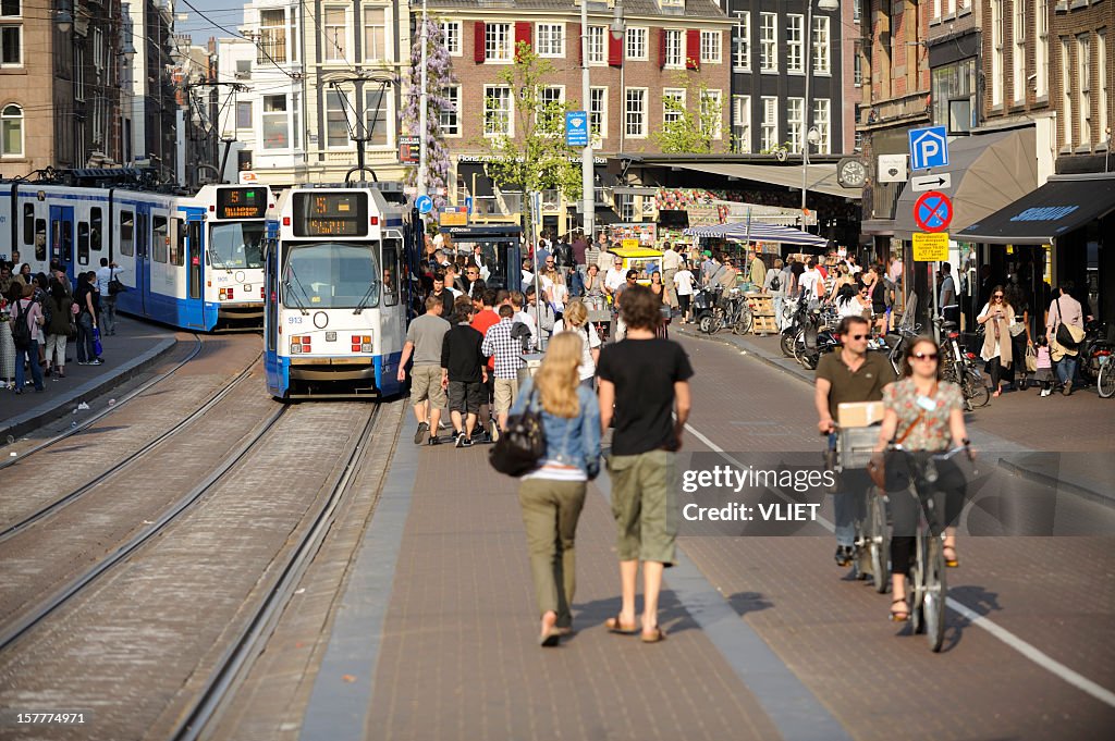 Street scene with trams and crowd of people in Amsterdam