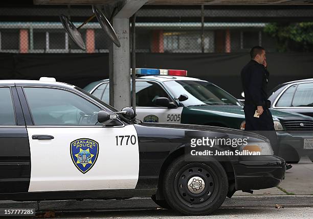 An Oakland Police officer walks by patrol cars at the Oakland Police headquarters on December 6, 2012 in Oakland, California. Oakland City officials...
