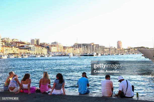 People setting by Le Vieux Port in Marseille city center on August 05 as a heatwave continues across northern Europe, with wildfires breaking out in...