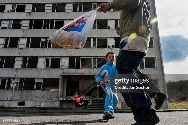 Boys, having their bag full of Easter eggs, happily dance in front of a devastated apartment block in the Gipsy ghetto of Chanov, Most, Czech...