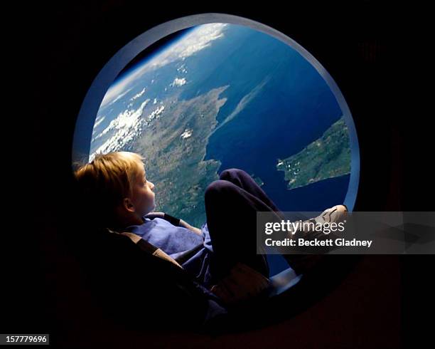 porthole view of earth - child globe stock-fotos und bilder