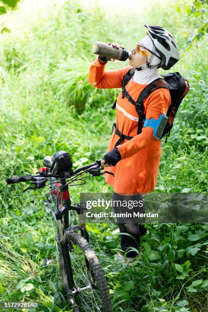 muslim woman riding bike in forest - veil isolated stock pictures, royalty-free photos & images