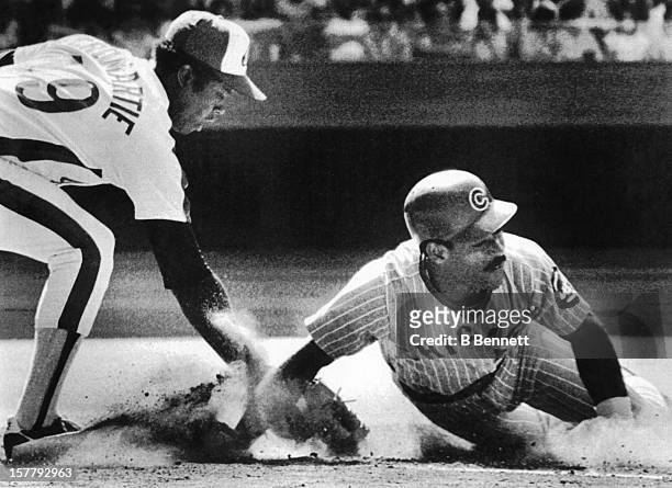 Ivan DeJesus of the Chicago Cubs dives back to first as Warren Cromartie of the Montreal Expos applies the tag during their game on July 13, 1980 at...