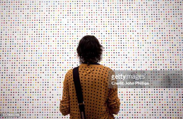 Woman Stands In Front Of A Damien Hirst Spot Painting During The Press View Of Damien Hirst'S Latest Work On Display At The Tate Modern.