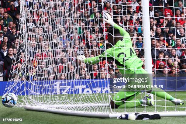 Lens' French forward Florian Sotoca scores past Manchester United's Cameroonian goalkeeper Andre Onana the first goal of his team during the...