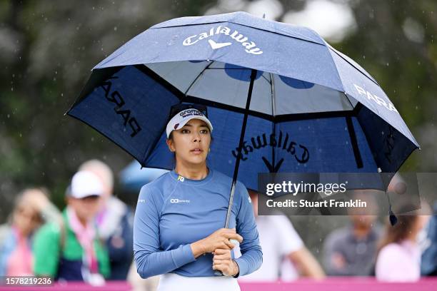 Alison Lee of the United States waits on the 13th hole with an umbrella during the Third Round of the Amundi Evian Championship at Evian Resort Golf...