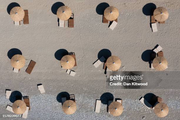 In an aerial view, empty sun loungers line the beach at a resort on July 29, 2023 in Gennadi, Rhodes, Greece. Since the wildfires that swept across...